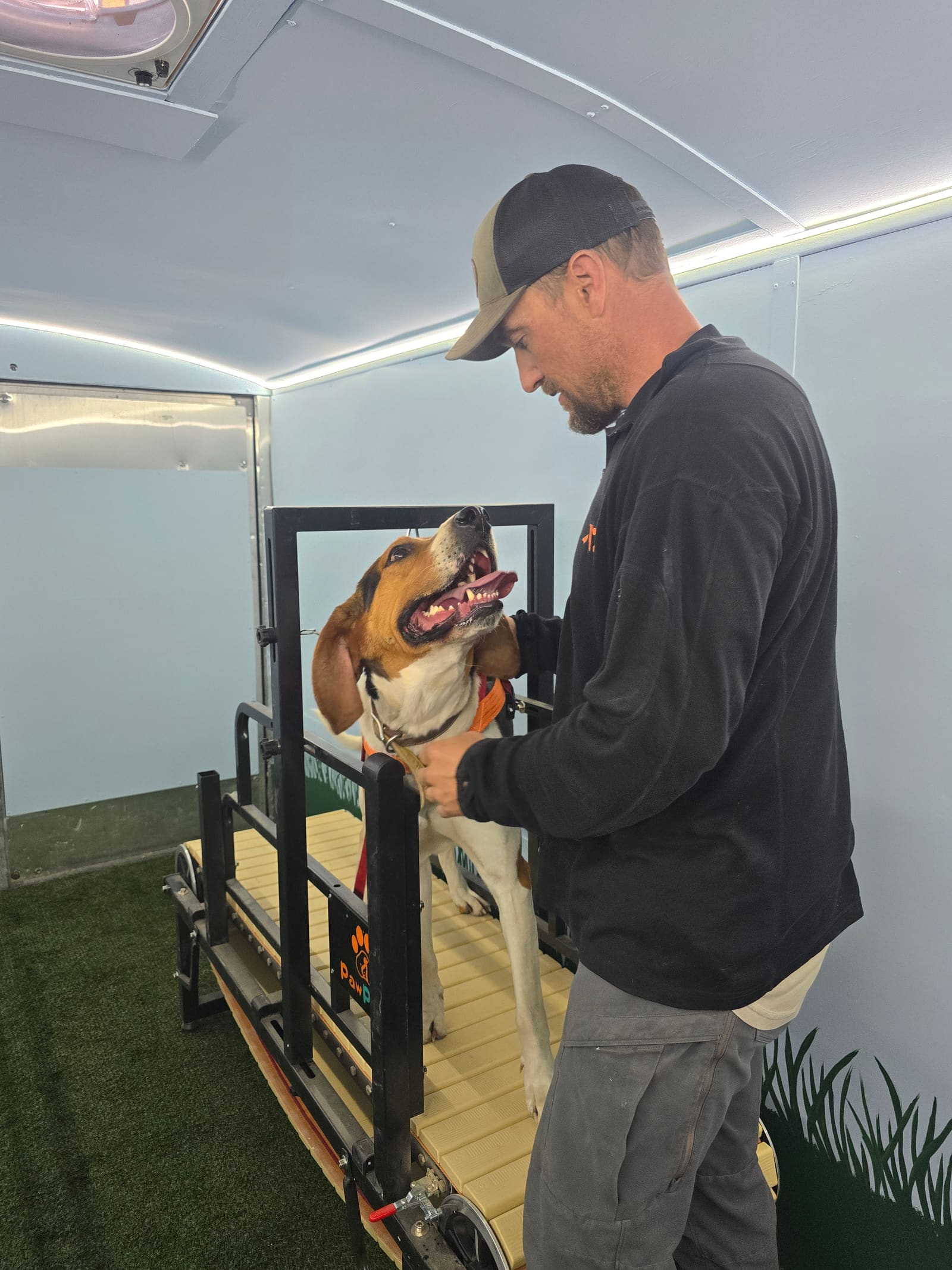 Zack working hands-on with a happy beagle inside the trailer